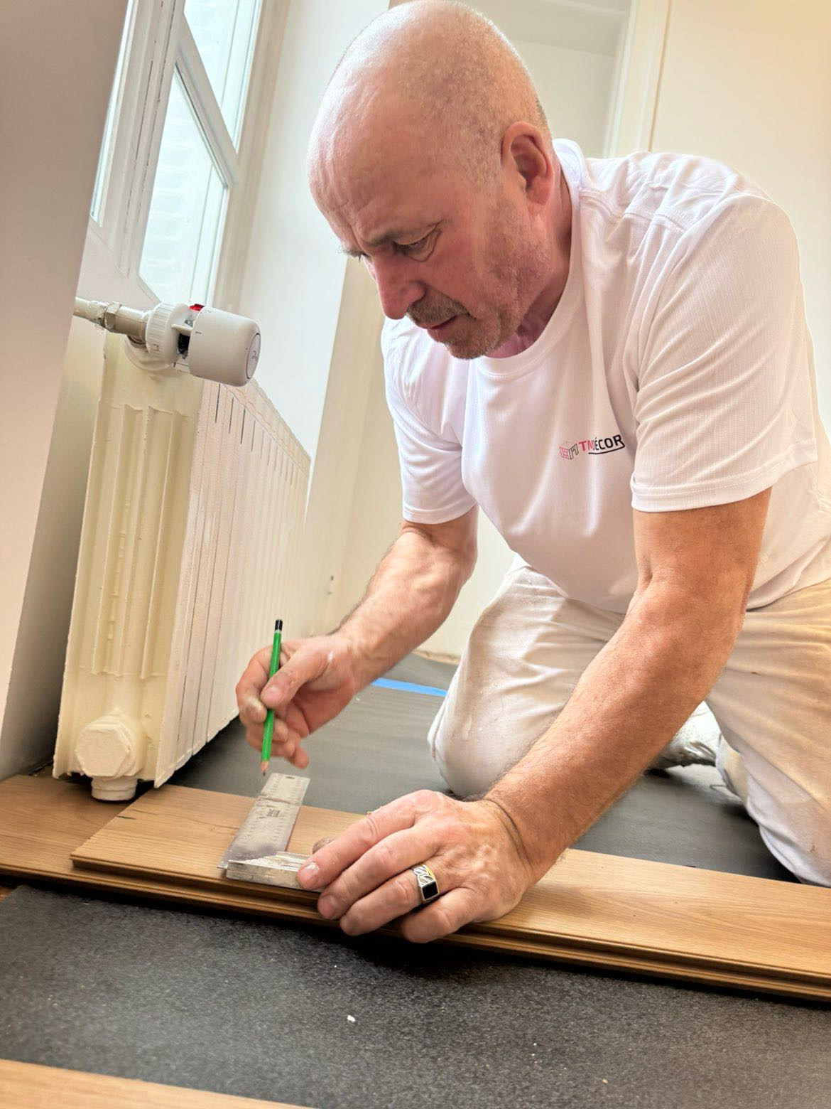 Artisan TM Décor prenant les mesures pour une pose de parquet