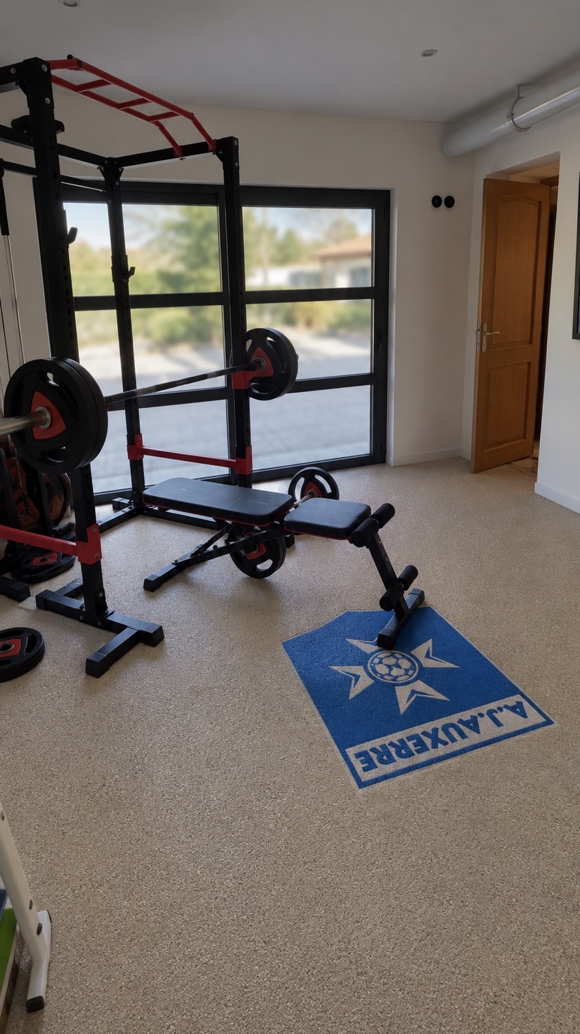 Garage transformé en salle de sport avec moquette de pierre en granulats de marbre et motif AJ Auxerre